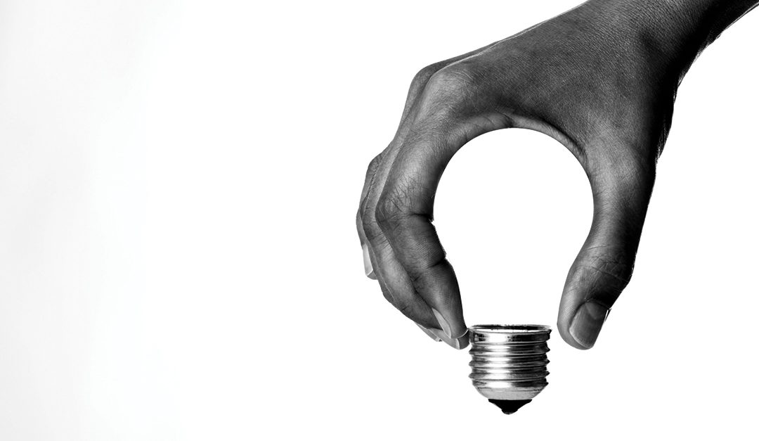 A hand forms the shape of a lightbulb, signifying industry innovation and disruption by technology